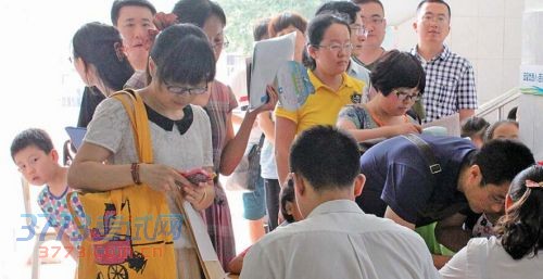 济南市东方双语实验学校小学一年级新生报名现场,一名小男孩在队伍里好奇地向前张望。本报记者 李飞 摄